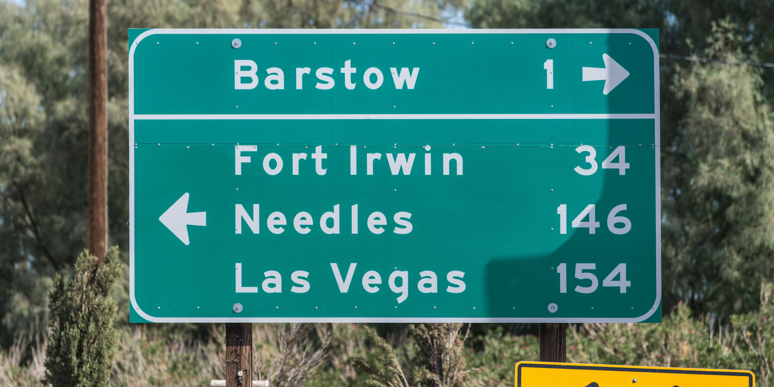 Highway directional sign pointing towards Barstow, Needles or Las Vegas in California’s Mojave desert.